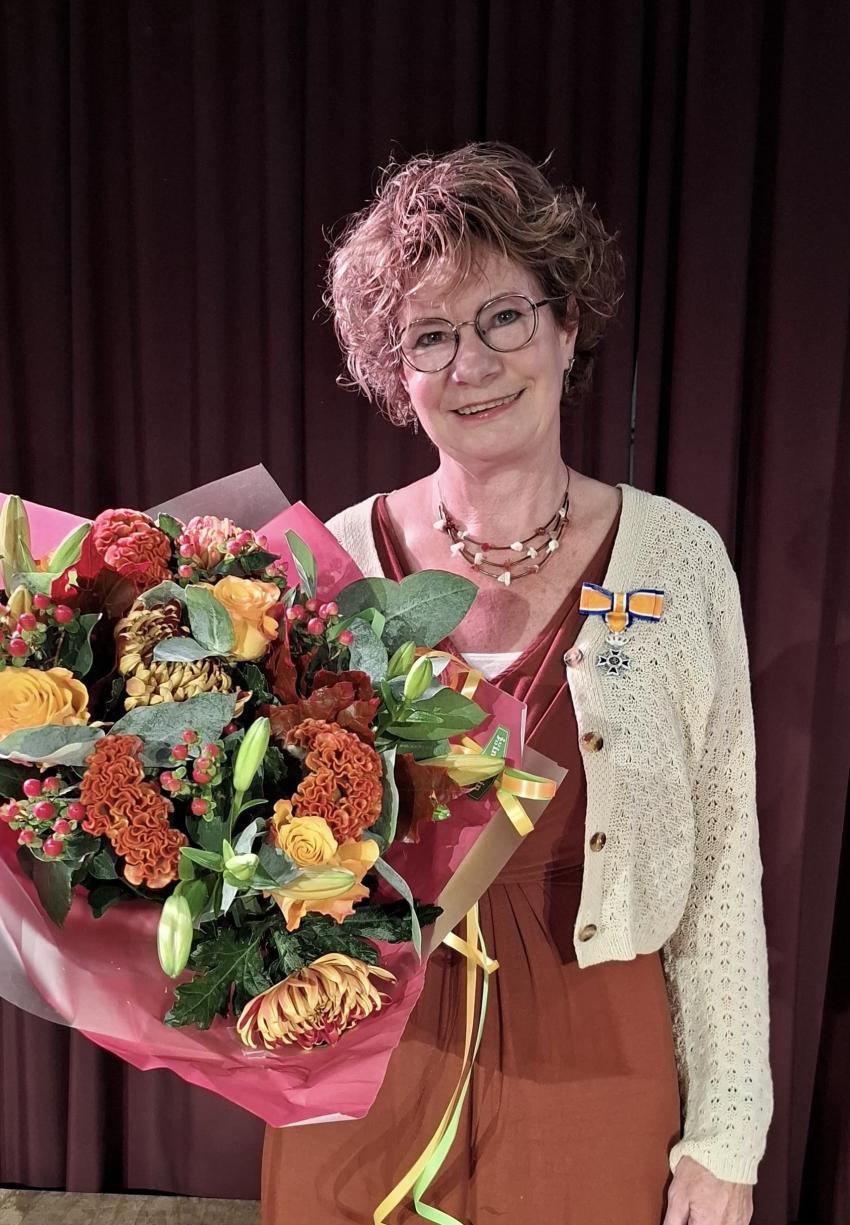 Marleen Boone ontvangt lintje en bos bloemen